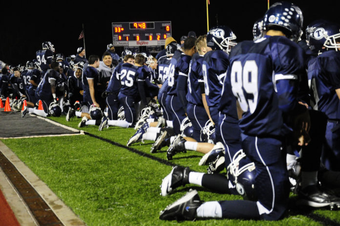 Football Team Shows Respect for Injured Opponent. Photo by Kathryn Hilger