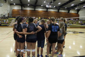 Junior Baylie Andersen and the rest of the JV volleyball team huddling together. Andersen's injury has effected the team in negative and positive ways. Photo by McKenna Rex.